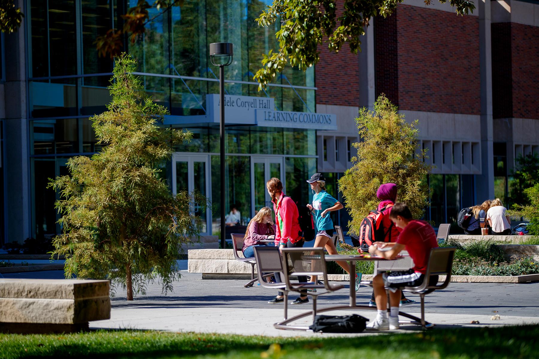 photo of students studying outdoors and
    walking to classes in front of the Learning Commons