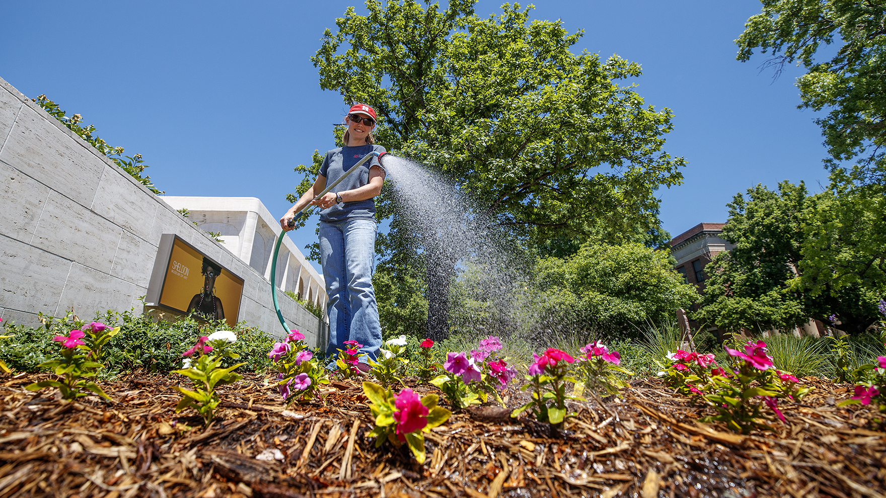 Karen Wilson with Landscape Services waters the flowers outside of the Sheldon Art Museum in this file photo from 2020.
