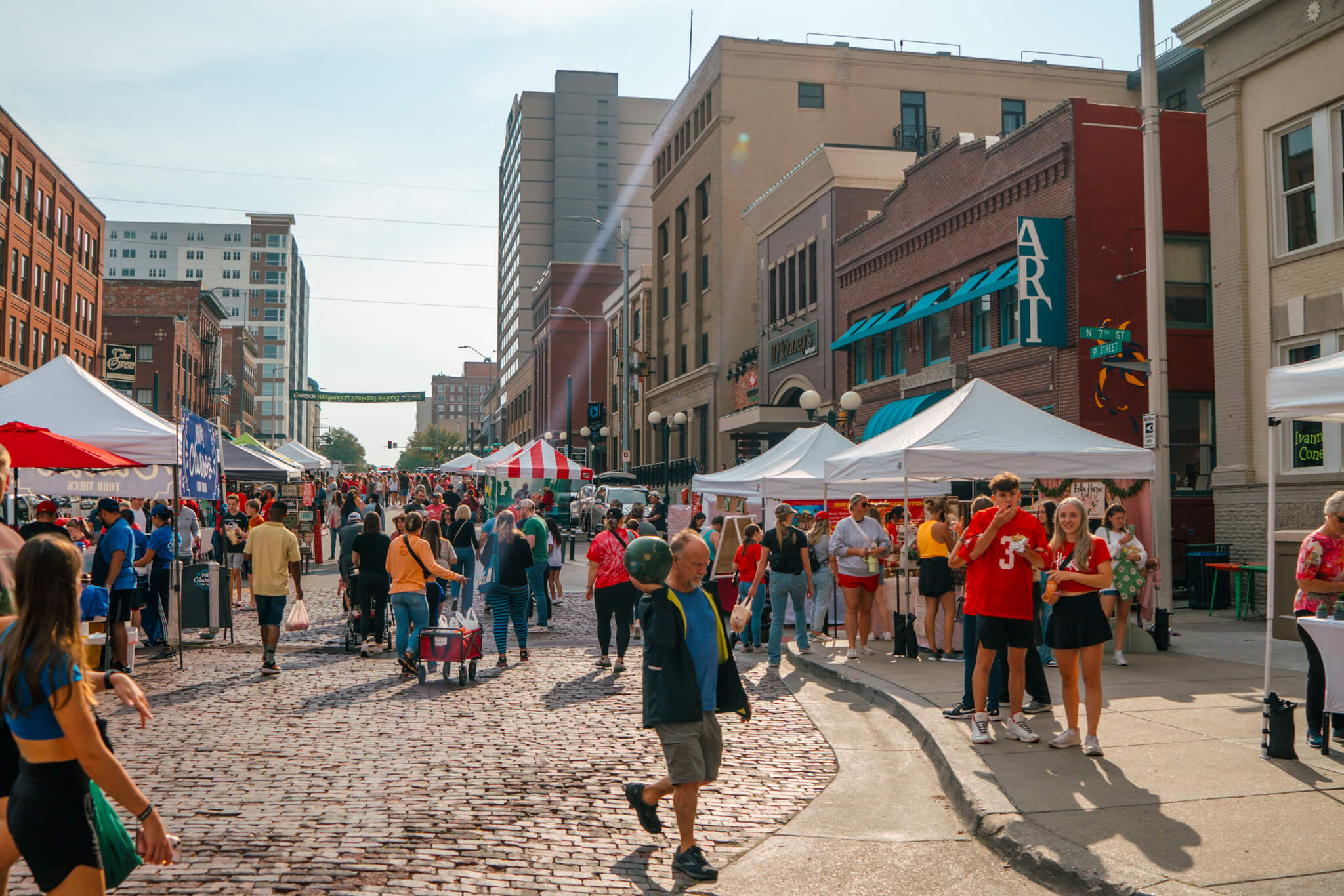 Farmers market in downtown Lincoln Haymarket area with people shopping for goods